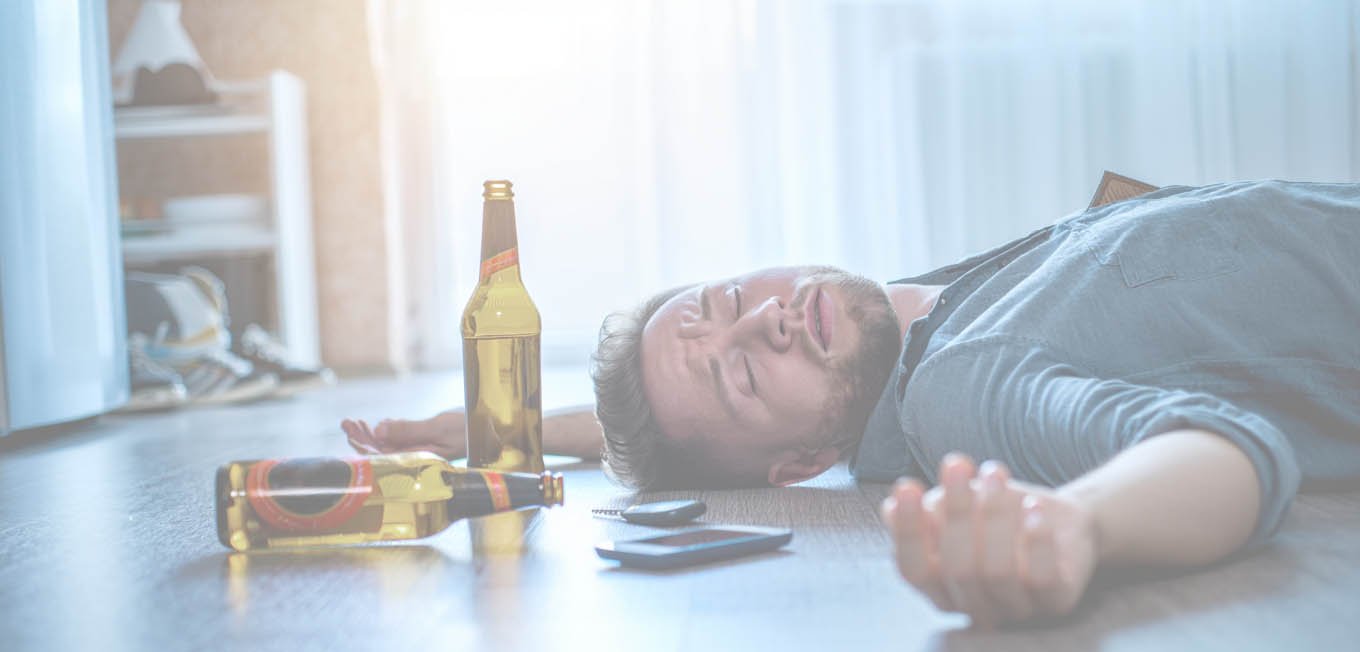 Мужчина с алкогольным отравлением лежит на полу